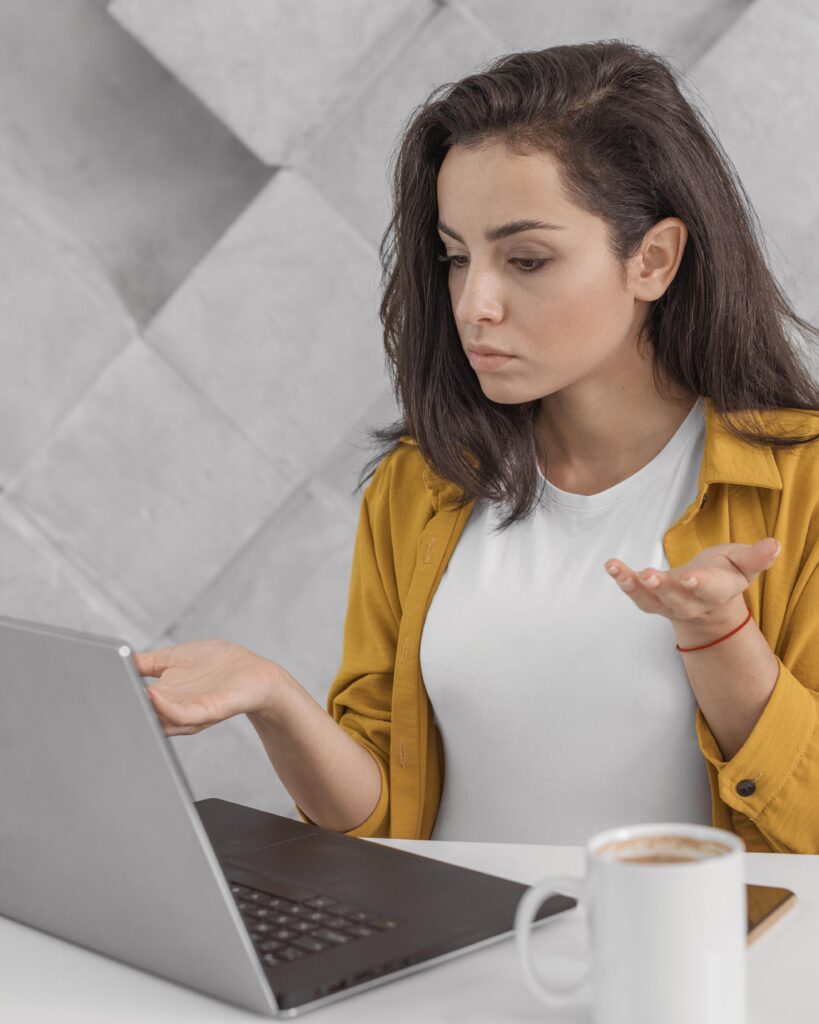 confused pregnant woman working from home with laptop